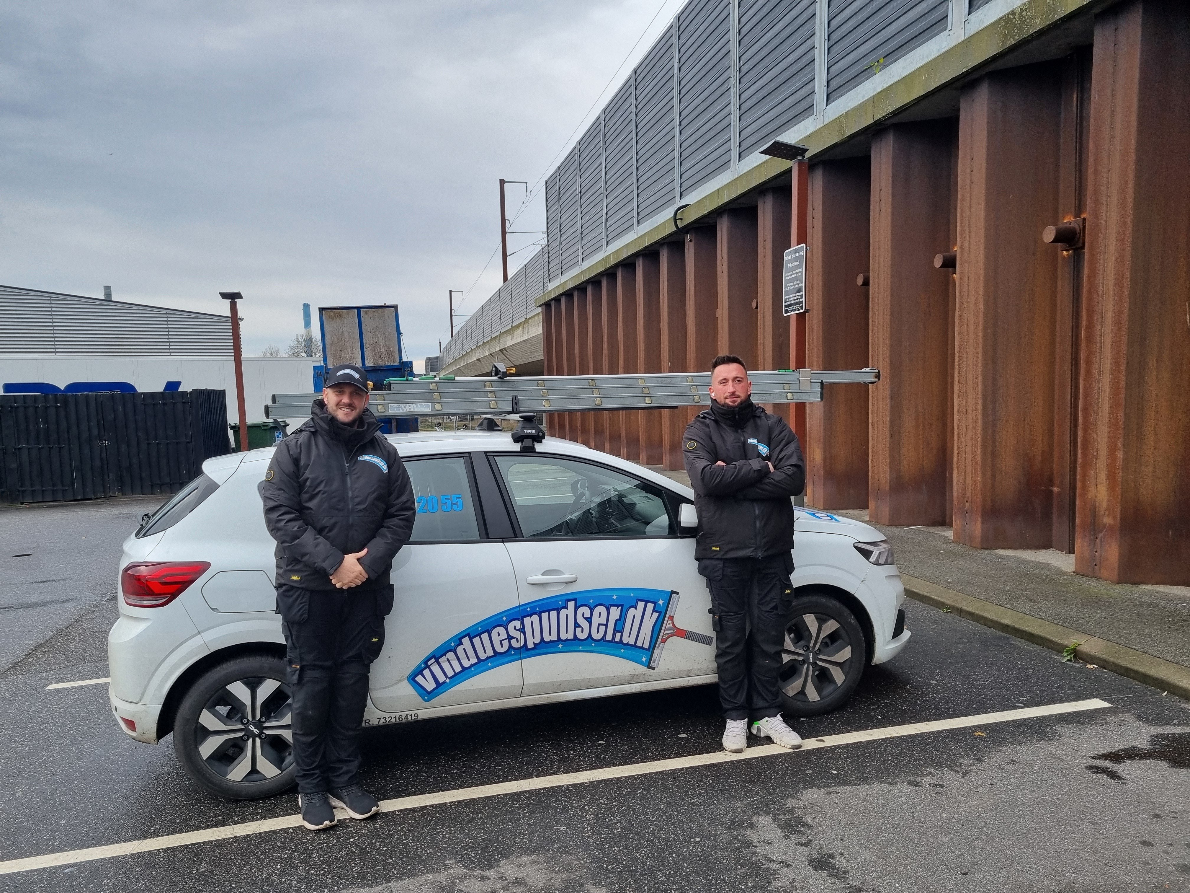 Vinduespudsere foran firmabil